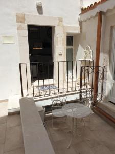 eine Terrasse mit einem Tisch und Stühlen auf dem Balkon in der Unterkunft Casa Bolle Ortigia in Syrakus