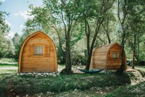 zwei kleine Holzhäuser in einem Park mit Bäumen in der Unterkunft TOP rafting center in Bovec