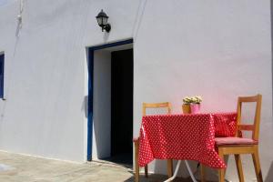 una mesa con un paño de lunares rojo y blanco en Cycladic houses in rural surrounding 4 en Tholária