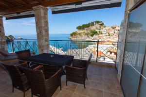 balcón con mesa, sillas y vistas al océano en Petros Penthouse, en Parga