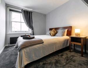sypialnia z dużym łóżkiem i oknem w obiekcie Highgate Maisonette with Roof Terrace w Londynie