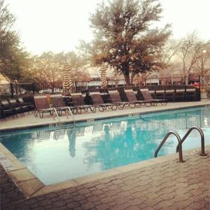 une grande piscine avec bancs dans l'établissement Hyatt Place Dallas/North Arlington/Grand Prairie, à Arlington