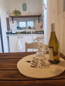 eine Flasche Wein und ein Glas auf dem Tisch in der Unterkunft Carmona's Patio in Eilat