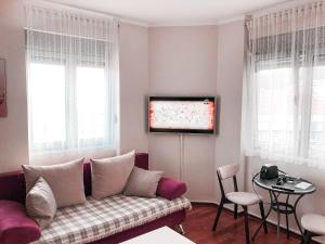 a living room with a couch and a flat screen tv at Lux View in Petrovac na Moru