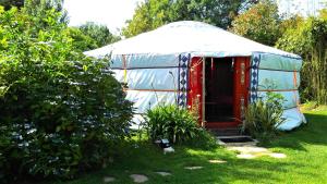 a yurt with a red door in a yard at yourte-kota-etretat in Les Loges