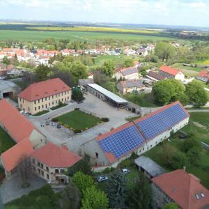 une vue aérienne d'une école avec des panneaux solaires sur les toits dans l'établissement Ferienwohnung Landwirtschaftliches Gut Taentzler, à Hecklingen