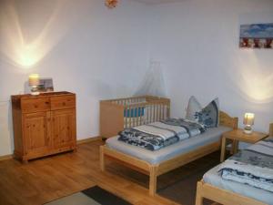 a bedroom with two beds and a wooden dresser at Ferienwohnung Landwirtschaftliches Gut Taentzler in Hecklingen