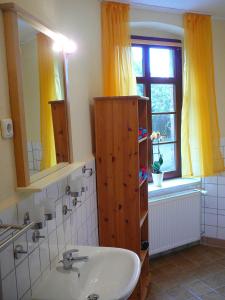 La salle de bains est pourvue d'un lavabo, d'un miroir et d'une fenêtre. dans l'établissement Ferienwohnung Landwirtschaftliches Gut Taentzler, à Hecklingen
