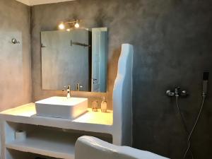 W łazience znajduje się biała umywalka i lustro. w obiekcie Cape Napos w mieście Faros