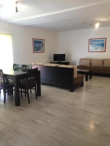 a living room with a couch and a table and chairs at Parque Mourabel, Oásis Village & Pé do Lago in Vilamoura