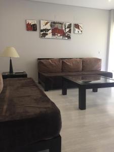a living room with a couch and a coffee table at Parque Mourabel, Oásis Village & Pé do Lago in Vilamoura