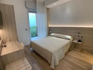 a bedroom with a large bed and a window at Hotel Beau Rivage Pineta in Lido di Jesolo