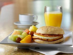 a plate with a sandwich and fruit and a glass of orange juice at Hyatt Place San Antonio Airport/Quarry Market in San Antonio