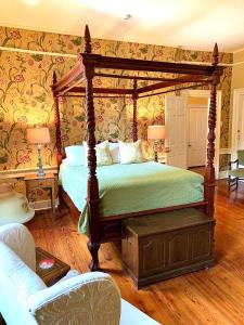 1 dormitorio con cama con dosel y sofá en The Lily Inn - Burlington en Burlington