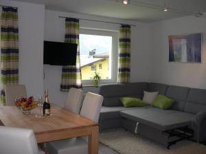 a living room with a couch and a table at Ferienwohnung Fritz 2 Obergeschoss in Stuhlfelden