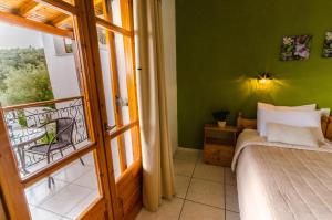 a bedroom with green walls and a bed and a window at Olive Grove View in Skiathos