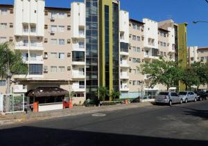 a large apartment building with cars parked in front of it at AP532 Thermas Paradise Cobertura Duplex 2 quartos in Rio Quente