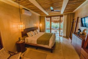a bedroom with a bed and a television in a room at Hotel Carolina Bacalar in Bacalar