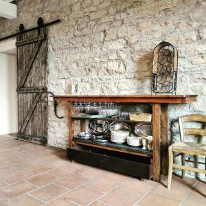 uma prateleira de madeira com panelas e frigideiras numa parede de pedra em Terraloft, Calme, Authenticité et Vue sur la vallée em Sombernon