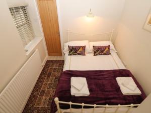 una piccola camera da letto con un letto in una stanza di Fir Tree Cottage a Criccieth