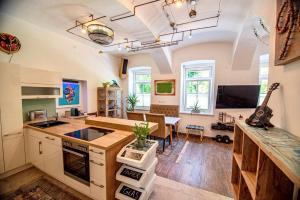 kuchnia i salon ze stołem i gitarą w obiekcie Ap9210 w mieście Pörtschach am Wörthersee