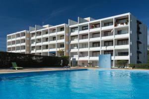 a hotel with a swimming pool in front of a building at Parque Mourabel, Oásis Village & Pé do Lago in Vilamoura