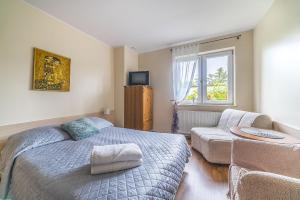 a bedroom with a bed and a couch and a window at Willa Michalinka in Jastarnia +82 photos