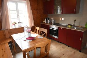 a kitchen with a wooden table and a kitchen with red cabinets at Ferienwohnung am Dorm in Süpplingenburg