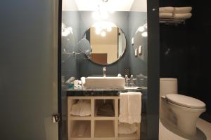 a bathroom with a toilet, sink and mirror at 1850 Hotel Boutique in Guanajuato