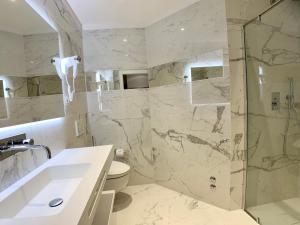 a bathroom with a shower and a sink and a toilet at Hotel Beau Rivage Pineta in Lido di Jesolo