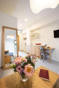 Μuses Suites في مدينة ريثيمنو: غرفة معيشة مع إناء من الزهور على طاولة