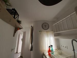 Pokój z zegarem na ścianie i oknem w obiekcie Ático Baños del Carmen w Kadyksie +19 zdjęć