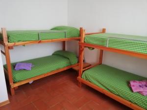 três beliches num quarto com lençóis verdes em Mia House em Porto Vecchio