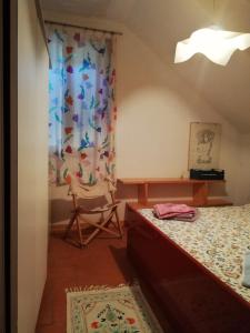 a bedroom with a bed and a chair and a window at Mia House in Porto Vecchio