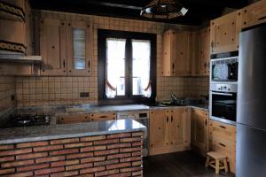 uma cozinha com armários de madeira e uma parede de tijolos em Bagadi em Arantza