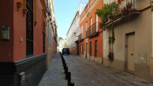 eine Gasse mit einem Auto, das eine Straße entlangfährt in der Unterkunft Apartamento Torres19 in Sevilla