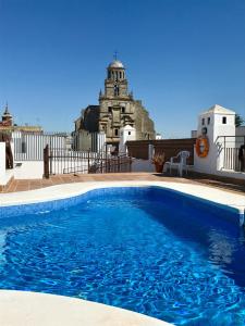 a blue swimming pool in front of a building at Apartamento San Juan, Parking privado in Jerez de la Frontera