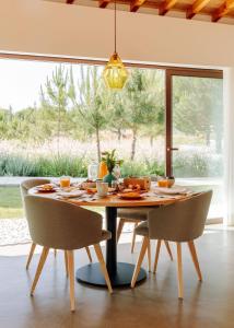 a dining room with a table and chairs and a window at Spatia Comporta in Comporta