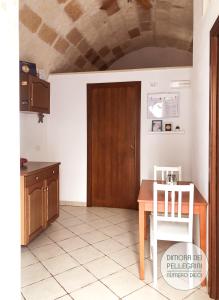 una cucina con tavolo e porta in legno di Dimora dei Pellegrini a Polignano a Mare