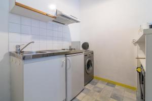 uma cozinha com um lavatório e uma máquina de lavar roupa em île d’Aix em Rochefort