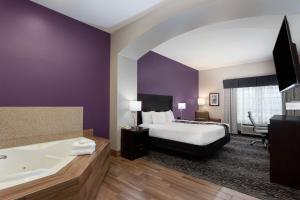 a hotel room with a large bed and a large mirror at La Quinta by Wyndham Huntsville Airport Madison in Madison
