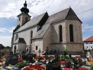 uma igreja com um cemitério em frente em Gästehaus Reingruber em Ried im Traunkreis