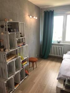 a room with a bed and a book shelf with books at Przystanek Przymorze in Gdańsk