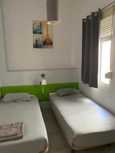 a bedroom with two beds and two lamps at Apartamentos Turia in Valencia