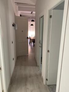 a person walking down a hallway with a door open at Apartamentos Turia in Valencia