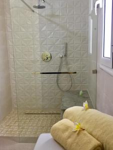 baño con ducha y puerta de cristal en Hotel Djerba Orient, en Mezraya