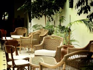 a group of wicker chairs and tables and plants at Solar De La Plaza in Salta