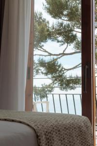 a bedroom with a bed and a view of a tree at Hotel Santa Marta in Lloret de Mar