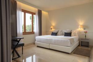 a white bedroom with a bed and a desk at Hotel Santa Marta in Lloret de Mar