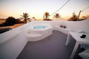 una vasca da bagno bianca seduta sul lato di un edificio di Eternity Suites Santorini a Firà